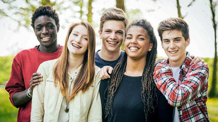5 teenagers smiling facing forward